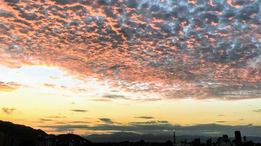 Sunset sky with dramatic clouds over a city silhouette